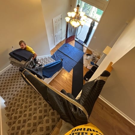 Pantheon Moving crew carrying large furniture items from a moving truck in Kansas City